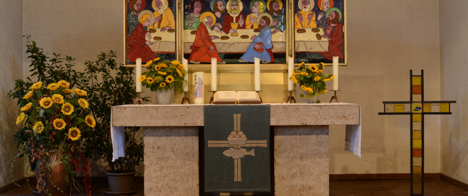 Geschmückter Altar mit angezündeten Kerzen und geöffnetem Altarbild